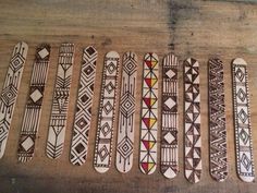 six wooden skateboards with designs on them sitting on a wood floor next to each other