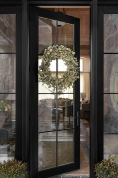 a wreath is hanging on the glass door