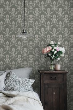 a bedroom with floral wallpaper and a bed