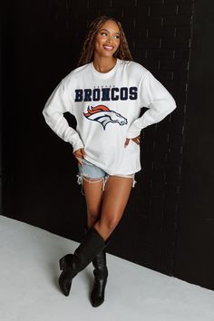 DENVER BRONCOS BIG GOALS OVERSIZED MIDWEIGHT LONG SLEEVE TEE Oversized Long Sleeve Athleisure T-shirt, White T-shirt With Ribbed Cuffs For College, White Athleisure Tops For Game Day, White Tops With Ribbed Cuffs For Sports Season, Long Sleeve Top With Team Name For Fall, White Varsity Top With Ribbed Cuffs, White Oversized Varsity Sweatshirt, Oversized White Varsity Sweatshirt, Collegiate Long Sleeve Top With Ribbed Cuffs