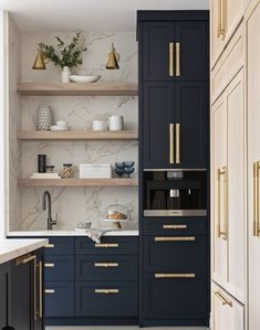 an open kitchen with blue cabinets and gold pulls on the doors, along with marble counter tops