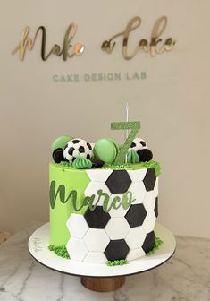 a cake decorated with soccer balls and green frosting