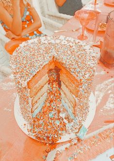 a large cake sitting on top of a table covered in sprinkles