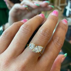 a close up of a person's hand wearing a ring with three stones on it