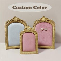 two gold frames with pink and blue velvet in front of a custom color sign that says,