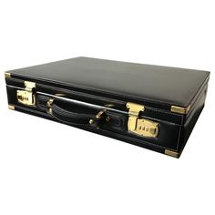 a black suitcase with gold handles on a white background