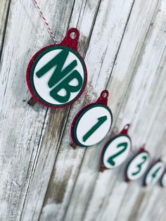 christmas ornaments hanging on a wooden fence with the number one and two in green, white and red