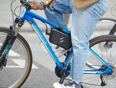 a man riding a blue bike down a street