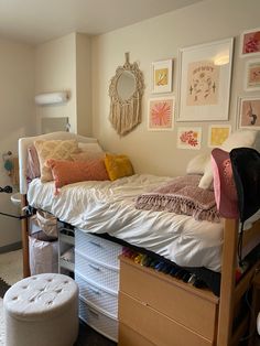 a bedroom with an unmade bed and lots of pictures on the wall above it