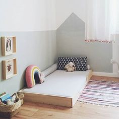 a child's room with a bed, rug and pictures on the wall above it