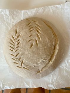 an uncooked round bread sitting on top of wax paper