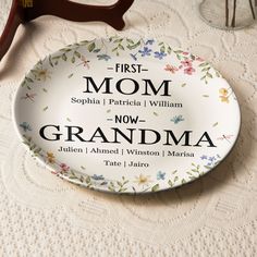 a plate with the words first mom and grandma printed on it next to some scissors