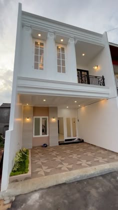 a white two story house with an attached balcony