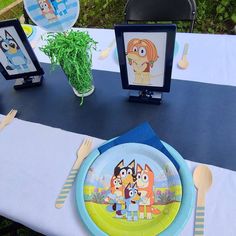 a table set up with plates, forks and napkins for children's birthday party