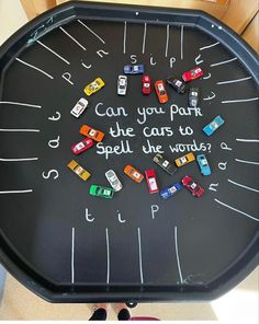 a black tray with cars on it that says can you park the cars to spell the word?