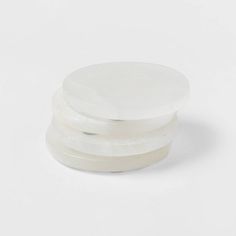 three round plastic containers on a white surface