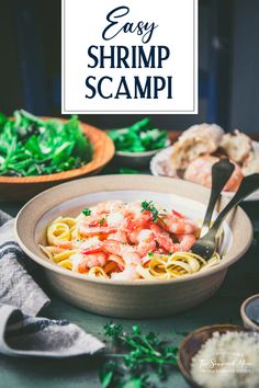 a bowl filled with pasta and shrimp on top of a table next to other dishes