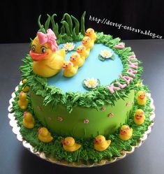 a birthday cake decorated with rubber ducks and grass