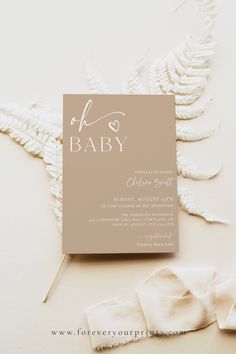 a card with the word hello baby written on it next to some white flowers and leaves