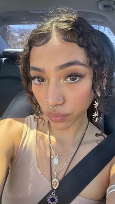 a woman with nose piercings sitting in a car