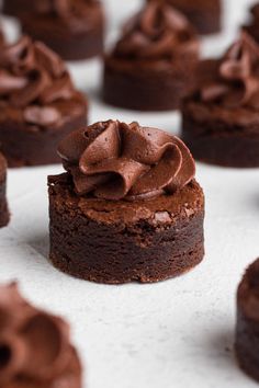 chocolate cupcakes with frosting sitting on top of each other