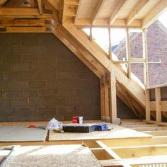 an unfinished attic with exposed rafters and wood flooring on the bottom half of it