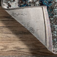 an area rug on top of a wooden floor with a blue and brown design in the middle