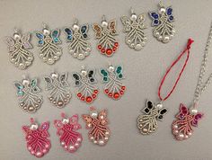 several necklaces with different designs and colors are displayed on a white surface, including one in the shape of a butterfly