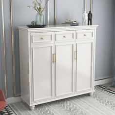 a white cabinet with gold handles in a room