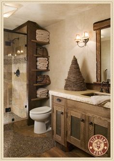 a bathroom with a toilet, shower and shelves filled with folded towels in the corner