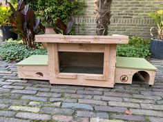 a dog house made out of pallet wood with a green cushion on the outside