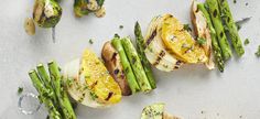 grilled asparagus and oranges on a white surface