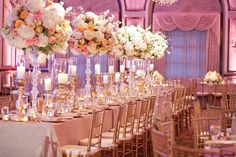 an elegant wedding reception with tall centerpieces and candles