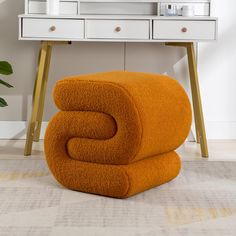 two orange towels stacked on top of each other in front of a dresser and mirror