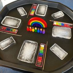 there are many different colored crayons on the trays and in front of them