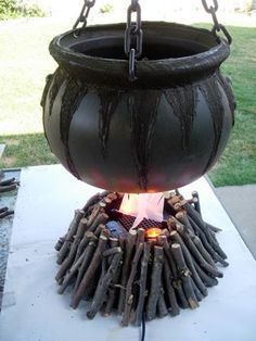 a large pot sitting on top of a fire pit with chains hanging from it's sides