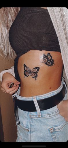 a woman's stomach with two butterflies on her belly and the bottom part of her stomach