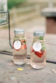 two mason jars filled with water and strawberries