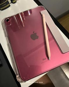 an ipad with a pen on top of it