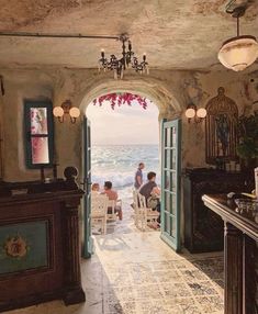 people are sitting in chairs at the end of an open door to a beach side restaurant