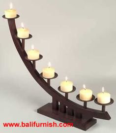 a wooden candle holder with many lit candles on it's side and the bottom half is curved