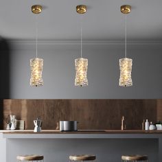 three lights hanging over a bar with stools