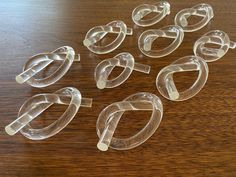 several clear plastic objects sitting on top of a wooden table