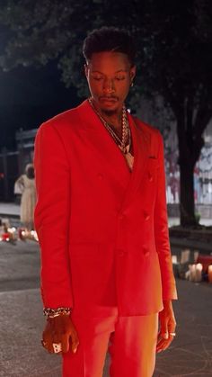 a man in a red suit standing on the street