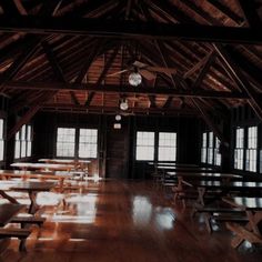 an empty room with tables and benches in the center, all made out of wood