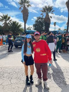 a man and woman standing next to each other in front of a parking lot full of people