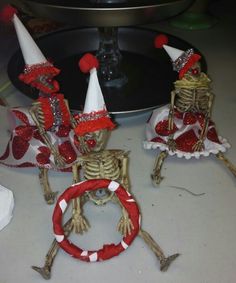 three skeleton figurines dressed in red and white