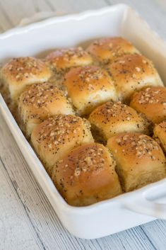 a casserole dish filled with rolls covered in sesame seeds