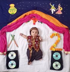 a baby is laying down in front of some speakers