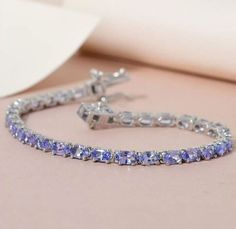 Elevate your style with this exquisite Charms Natural Tanzanite Tennis Bracelet crafted in 925 Sterling Silver. This bracelet features a stunning oval-shaped natural Tanzanite gemstone with a beautiful blue color and excellent cut grade. The gemstone is set in a prong style and measures 6mm in length, giving the bracelet a unique and elegant look. This bracelet is handmade with a hook closure and curb link chain type, making it easy to wear and adjust. It is perfect for anniversaries or any special occasion. With a total carat weight of 15, this bracelet is a true representation of nature's beauty. The charm is signed and comes with a seller warranty for added peace of mind. Tanzanite Bracelet, Tanzanite Gemstone, Natural Tanzanite, Fine Jewelry Bracelets, Bracelet Crafts, Bracelets And Charms, Tennis Bracelet, Nature Beauty, Link Chain